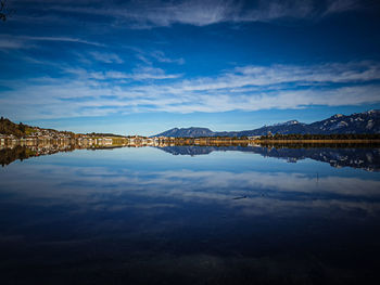 Scenic view of lake by mountain against sky