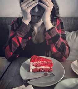 Close-up of young woman with cake on table