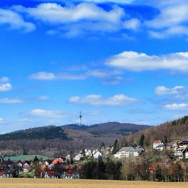 mountain, sky, landscape, cloud - sky, built structure, mountain range, building exterior, architecture, blue, cloud, field, scenics, nature, hill, beauty in nature, tranquil scene, house, tranquility, day, village