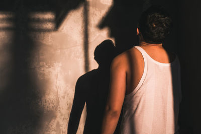 Rear view of man standing by wall