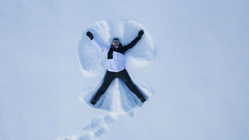 Woman making snow angel