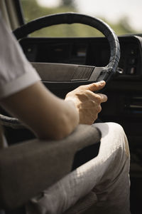 Midsection of man sitting in car