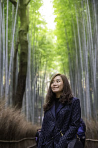 Smiling woman looking away in forest