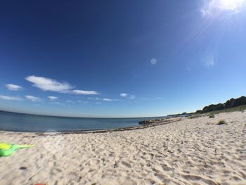 Scenic view of sandy beach against blue sky