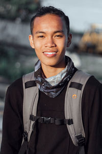 Portrait of smiling young man standing outdoors