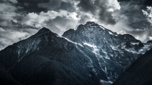 Low angle view of mountains against cloudy sky