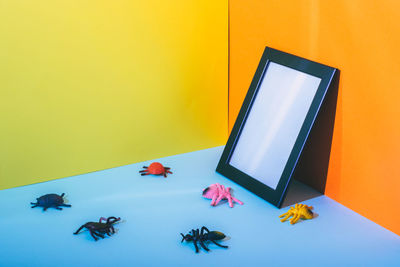 High angle view of multi colored pencils on table against yellow wall