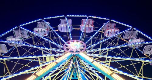 Low angle view of illuminated ferris wheel against sky at night