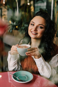 Portrait of woman with coffee cup in restaurant