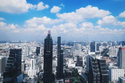 Aerial view of buildings in city against sky