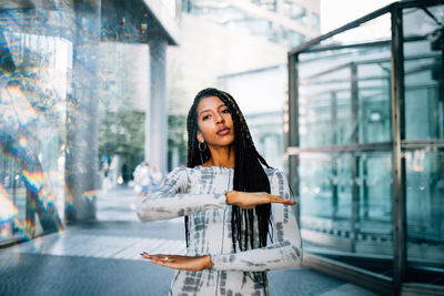 Portrait of beautiful young woman gesturing while standing on floor