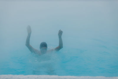 Rear view of woman swimming in pool