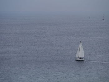 Sailboat sailing on sea against sky