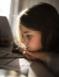 Close-up of girl leaning on table at home