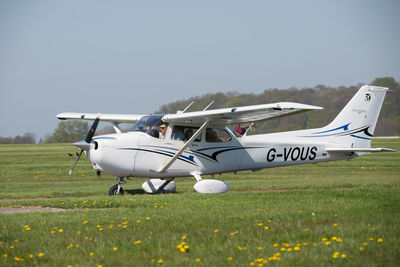 Airplane on field against sky