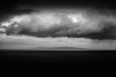 Scenic view of sea against storm clouds