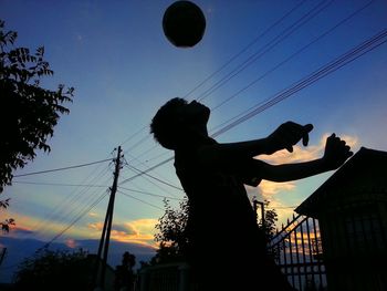 Low angle view of silhouette people against blue sky at sunset