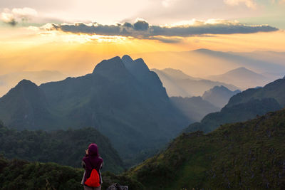 Man standing on mountain against sky during sunset