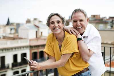 Portrait of happy senior couple standing on terrace