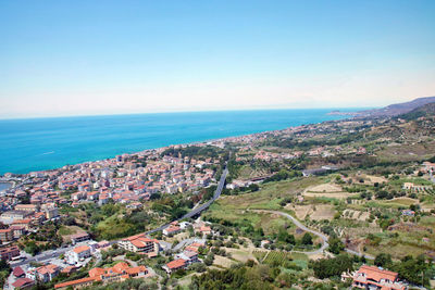 High angle view of townscape by sea against clear sky