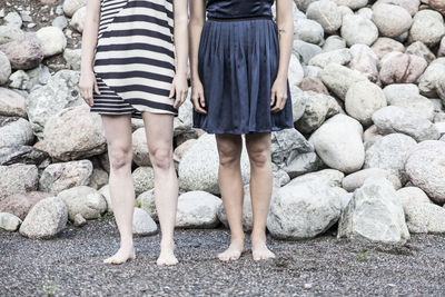 Low section of two people standing on rocks