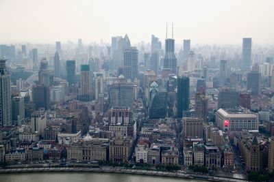 Aerial view of buildings in city against sky