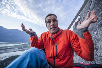 Man with surprised look showing interrogation on portaledge at sunset
