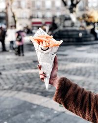 Person holding ice cream cone on street