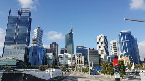 Skyscrapers in city against blue sky