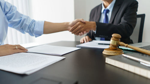 Midsection of lawyer working at desk in office