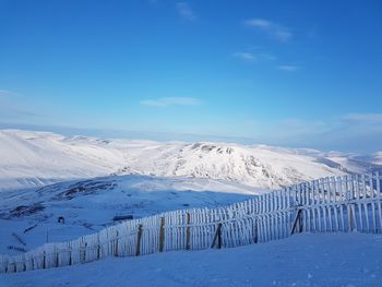 Scenic view of snowcapped mountains against blue sky