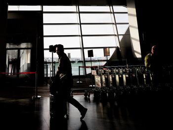 Side view of silhouette man standing on glass window