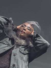 Low angle view of woman with plastic on face against sky