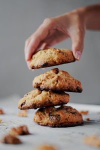 Cropped hand holding cookies over table