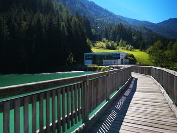 Footbridge over lake against mountains