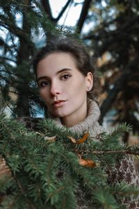 Portrait of young woman against trees