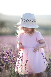 Smiling girl wearing hat standing on field
