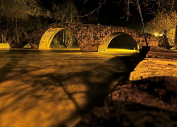 Bridge over river in city at night