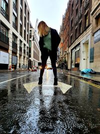 Full length of man standing on wet street in rainy season