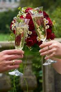 Cropped hands of couple toasting champagne flutes