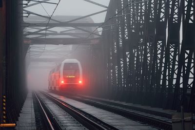 Train on railway bridge in foggy weather