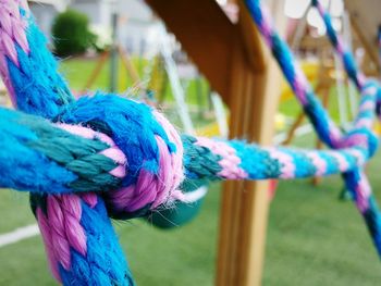 Close-up of blue tied to rope on field