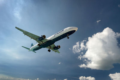 Low angle view of airplane flying against sky