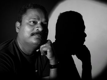 Close-up of man sitting in darkroom