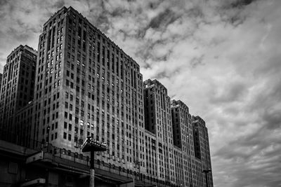 Low angle view of buildings against cloudy sky