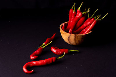 Close-up of red chili peppers on table against black background
