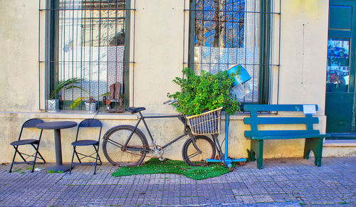 Empty bench on sidewalk against building