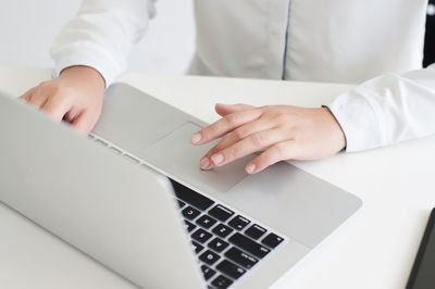 Midsection of man using laptop on table