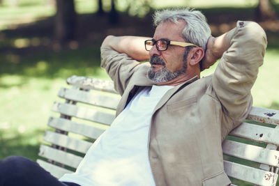 Mature man sitting on bench at park
