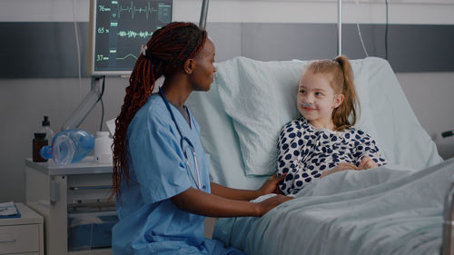 Nurse talking with girl at hospital